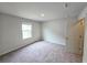 This carpeted bedroom has a light wall color and a large window offering natural light at 660 Redhead Way (Lot 24), Grayson, GA 30017