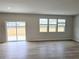 Bright living room with hardwood floors, large windows, and a sliding glass door at 660 Redhead Way (Lot 24), Grayson, GA 30017