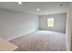 This carpeted loft has a light wall color and a large window offering natural light at 660 Redhead Way (Lot 24), Grayson, GA 30017