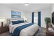 Comfortable bedroom with blue accents, soft lighting, and a large window for natural light at 7437 Nulan Way, Riverdale, GA 30274
