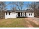 Charming single-story home featuring a brick facade, dark shutters, and a covered front porch at 7437 Nulan Way, Riverdale, GA 30274