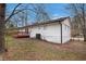 Side and rear exterior of home with a small deck and white painted wood and a gated yard at 7437 Nulan Way, Riverdale, GA 30274