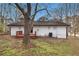 Rear exterior of home with a small deck and white painted wood, trees, and partial grass yard at 7437 Nulan Way, Riverdale, GA 30274