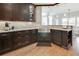 An open concept kitchen featuring granite countertops, custom dark cabinetry, stainless steel sink, and hardwood floors at 764 Sharpshooters Nw Rdg, Marietta, GA 30064
