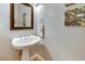 Stylish powder room featuring a pedestal sink, decorative mirror, and elegant wall art at 764 Sharpshooters Nw Rdg, Marietta, GA 30064