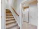 Carpeted stairway leading to an adjacent room with a refrigerator and white cabinets at 764 Sharpshooters Nw Rdg, Marietta, GA 30064