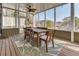 A screened sunroom featuring wood floors, a dining set, and beautiful views of the surrounding trees and nature at 764 Sharpshooters Nw Rdg, Marietta, GA 30064