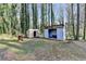 View of the backyard with storage sheds, green grass, and mature trees at 2773 Marcia Dr, Lawrenceville, GA 30044