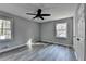 Bedroom with a black ceiling fan and grey wood-look flooring, with two windows providing natural light at 2773 Marcia Dr, Lawrenceville, GA 30044