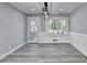 Bright dining area features modern lighting fixture, gray plank flooring, and access to the outdoor deck at 2773 Marcia Dr, Lawrenceville, GA 30044