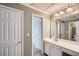 Neutral bathroom with tiled shower and vanity with an expansive mirror at 5106 Vinings Estates Se Way, Mableton, GA 30126