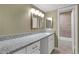 Bathroom vanity featuring a large countertop, modern lighting, and a view into a tiled bath/shower area at 80 Montre Nw Sq, Atlanta, GA 30327