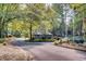 Community entrance with small building and landscaped circular drive among mature trees and greenery at 80 Montre Nw Sq, Atlanta, GA 30327