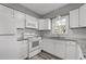 Bright kitchen featuring white cabinetry, granite countertops, stainless steel appliances, and tile backsplash at 80 Montre Nw Sq, Atlanta, GA 30327