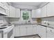 Well-lit kitchen features white cabinets, granite countertops, and modern appliances, designed for both style and functionality at 80 Montre Nw Sq, Atlanta, GA 30327