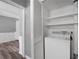 Bright laundry area with washer, shelving, and louvered closet, providing efficient space and organization at 80 Montre Nw Sq, Atlanta, GA 30327