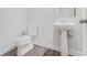 A neutral half-bath features a pedestal sink and a modern toilet on wood-look floors at 139 Jameson E Dr, Acworth, GA 30102
