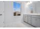 Bathroom with double vanity with white cabinets, large windows, and tile floors at 139 Jameson E Dr, Acworth, GA 30102