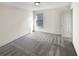 Bright bedroom features soft carpet, neutral walls, and a window overlooking the yard at 3671 Salvia Dr, Buford, GA 30519