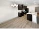 An open-concept kitchen with an island, modern lighting, and stainless steel appliances at 3671 Salvia Dr, Buford, GA 30519