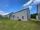 Backyard view of the home's neutral siding, green lawn, and patio area at 117 Oliver Dr, Locust Grove, GA 30248