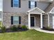 Home's front entrance with brick accents and manicured landscaping at 117 Oliver Dr, Locust Grove, GA 30248