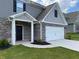 Up close exterior of a two-story home with gray siding, brick accents, and a two-car garage at 117 Oliver Dr, Locust Grove, GA 30248