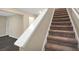 Carpeted staircase with a white handrail providing a transition between floors at 117 Oliver Dr, Locust Grove, GA 30248