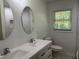 Bathroom with a dual sink vanity, decorative mirrors, and a tiled shower at 4222 Castle Pines Ct, Tucker, GA 30084