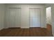 Bedroom featuring hardwood floors, white walls, and ample closet space at 4222 Castle Pines Ct, Tucker, GA 30084