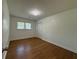 Clean, well-lit bedroom with hardwood floors, neutral walls, and a large window at 4222 Castle Pines Ct, Tucker, GA 30084