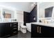 Chic bathroom featuring sleek black cabinetry, dual sinks, a soaking tub, and elegant gold fixtures at 1110 Vernon Springs Ct, Atlanta, GA 30327