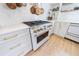 Bright kitchen features a white stove with brass fixtures, white cabinets, and light hardwood flooring at 1110 Vernon Springs Ct, Atlanta, GA 30327