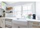 Bright kitchen featuring white cabinets, countertops, a farmhouse sink, and stainless steel appliances at 1110 Vernon Springs Ct, Atlanta, GA 30327