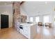 Open concept living area with kitchen island, brick fireplace, and large windows at 1110 Vernon Springs Ct, Atlanta, GA 30327