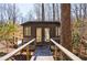 Exterior view of outbuilding with a deck and railing surrounded by mature trees, offering a secluded retreat at 1110 Vernon Springs Ct, Atlanta, GA 30327