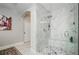 Bathroom displaying a glass-enclosed marble shower with seating, complemented by marble flooring and a door at 2480 Copper Mill Trl, Cumming, GA 30041