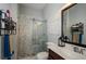 Modern bathroom with a glass-enclosed shower, marble-style tile, and vanity with a sleek countertop at 2480 Copper Mill Trl, Cumming, GA 30041