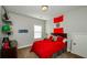 Bedroom showcasing a red-themed design with decorations and a double bed, enhanced by natural light at 2480 Copper Mill Trl, Cumming, GA 30041