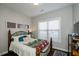 Inviting bedroom showcasing a decorative iron bed frame and a brightly lit window at 2480 Copper Mill Trl, Cumming, GA 30041