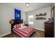 Bedroom featuring a double bed and decorative shelving, enhanced by natural light from a window at 2480 Copper Mill Trl, Cumming, GA 30041