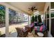 Relaxing covered patio with comfortable seating, ceiling fan, and views of the lush backyard at 2480 Copper Mill Trl, Cumming, GA 30041