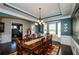 Elegant dining room featuring hardwood floors, a bay window, and a decorative chandelier above a formal table at 2480 Copper Mill Trl, Cumming, GA 30041