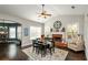 Dining room boasts a fireplace, dark table, large windows and view of open floor plan at 2480 Copper Mill Trl, Cumming, GA 30041