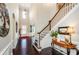 Inviting foyer boasts dark hardwood floors, a staircase, and a view into the dining room at 2480 Copper Mill Trl, Cumming, GA 30041