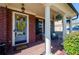 Welcoming covered porch with brick columns, seating, and decorative accents at 2480 Copper Mill Trl, Cumming, GA 30041