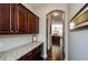 Inviting hallway featuring dark cabinetry with granite countertops and an arched entrance to the modern kitchen at 2480 Copper Mill Trl, Cumming, GA 30041