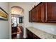 Hallway view showcasing an open layout leading to the dining room with granite countertop and dark cabinetry at 2480 Copper Mill Trl, Cumming, GA 30041