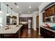 Modern kitchen featuring dark wood cabinets, granite countertops, stainless steel appliances, and ample storage space at 2480 Copper Mill Trl, Cumming, GA 30041