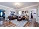 Spacious living room featuring hardwood floors, a decorative rug, a plush leather sofa, and stylish decor at 2480 Copper Mill Trl, Cumming, GA 30041